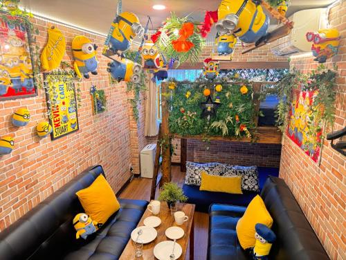 a room with a couch and a table and a brick wall at Hotel Orange House in Osaka