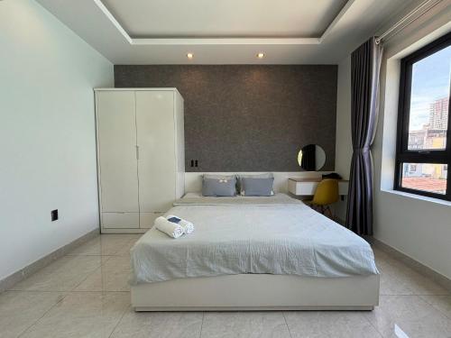 a bedroom with a large white bed with blue pillows at Sea House Hotels and Apartments in Vung Tau