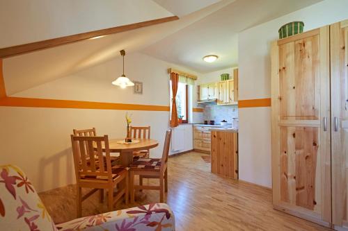 a kitchen and dining room with a table and chairs at Apartments Organic Tourist Farm Gradišnik in Prevalje
