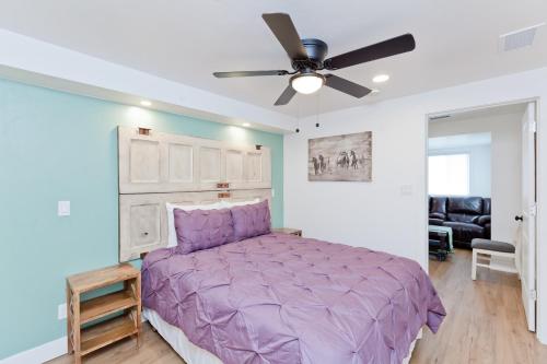 una camera con letto viola e ventilatore a soffitto di River City Hideaway cottage a Grand Junction