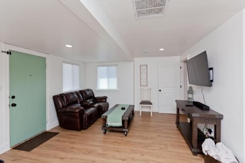 un soggiorno con un divano in pelle e un tavolo di River City Hideaway cottage a Grand Junction