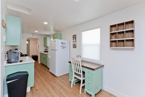 a kitchen with green cabinets and a white refrigerator at River City Hideaway cottage in Grand Junction