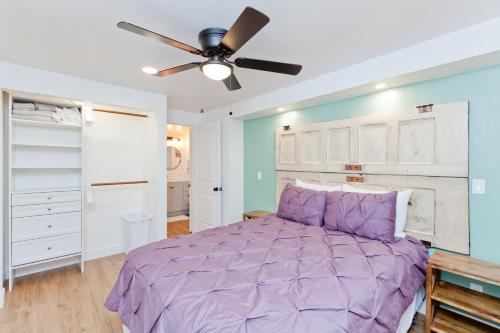 a bedroom with a purple bed and a ceiling fan at River City Hideaway cottage in Grand Junction