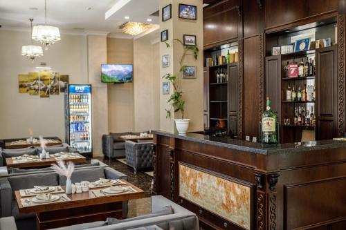 a bar in a restaurant with couches and tables at Park Hotel al Bustan in Shymkent