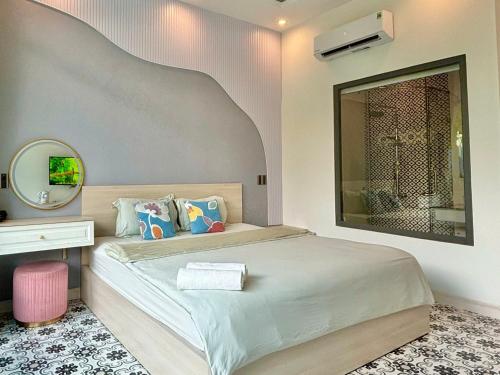 a bedroom with a large bed and a mirror at Sea House Hotels and Apartments in Vung Tau