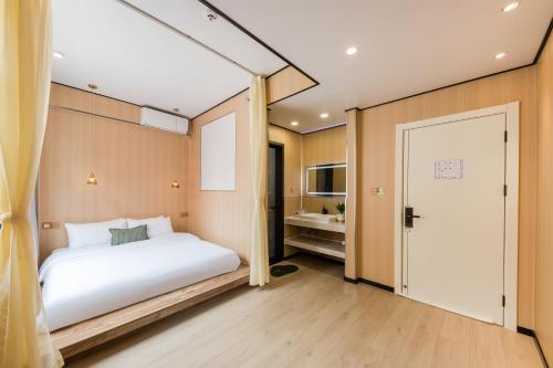 a bedroom with a white bed and a sliding door at Quanzhou West Street Kaiyuan Temple Bandiao Inn in Quanzhou
