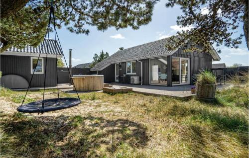 a house with a swing in the yard at Holiday Home Tane Hedevej Blåvand X in Blåvand