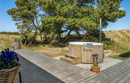 a wooden deck with a hot tub and a tree at Holiday Home Tane Hedevej Blåvand X in Blåvand