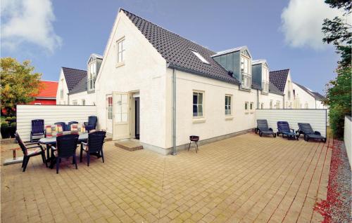 a house with a patio with a table and chairs at Three-Bedroom Holiday Home In Blavand in Blåvand