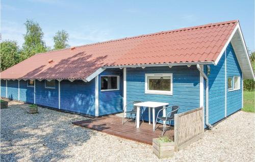 a blue house with a table on a deck at Holiday Home Blomstervangen Denmk Iv in Oksbøl