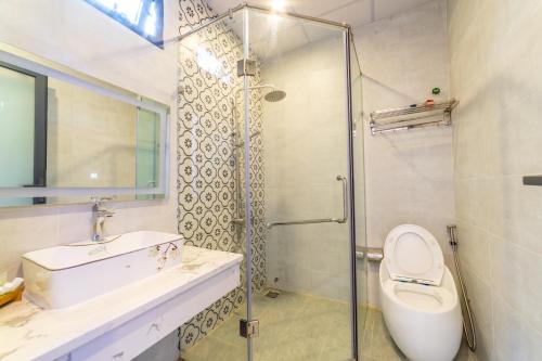 a bathroom with a shower and a toilet and a sink at Sea House Hotels and Apartments in Vung Tau