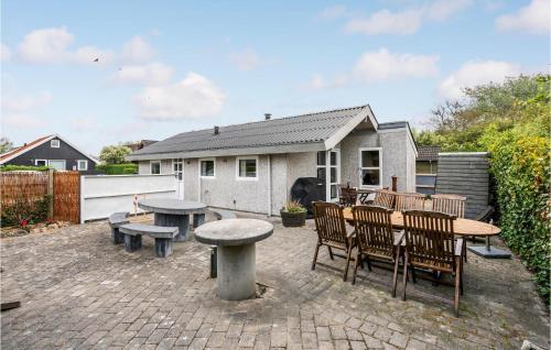 a patio with a table and chairs and a table and benches at Holiday Home Hemmet 37 in Falen