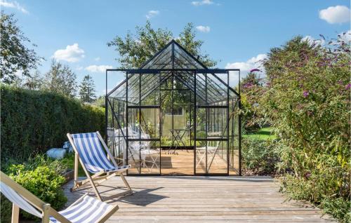 a glass gazebo with two chairs on a wooden deck at 3 Bedroom Stunning Home In Gilleleje in Gilleleje