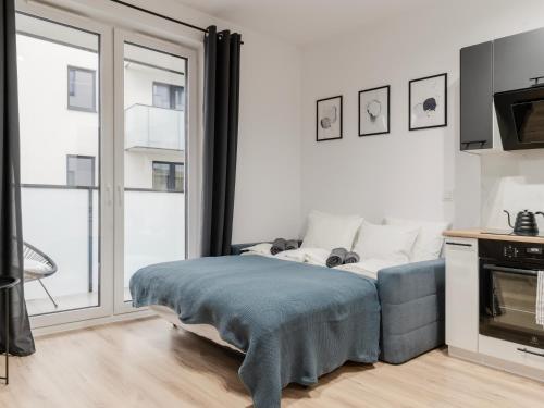 a bedroom with a bed and a large window at City Spot Łódź by Aparo - Manufaktura, Nowy Apartament, PlayStation, Miejsce do Pracy, Winda, Balkon in Łódź