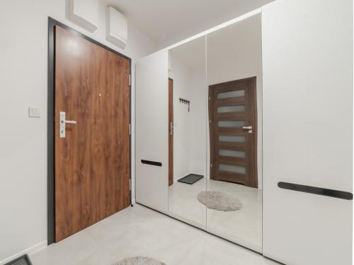 a pivot door in a bathroom with white walls at City Spot Łódź by Aparo - Manufaktura, Nowy Apartament, PlayStation, Miejsce do Pracy, Winda, Balkon in Łódź