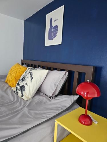 a bedroom with a bed with a red lamp on a table at Midtown Duplex Ratchayothin in Bangkok