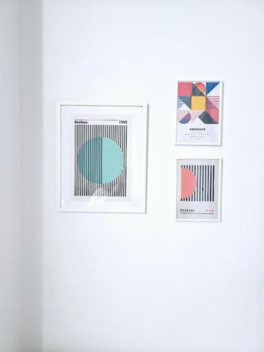 three pieces of art on a white wall at Midtown Duplex Ratchayothin in Bangkok