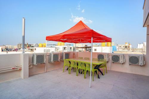 a table and chairs on a balcony with an umbrella at FabHotel Galaxy Heights - Nagavara in Bengaluru