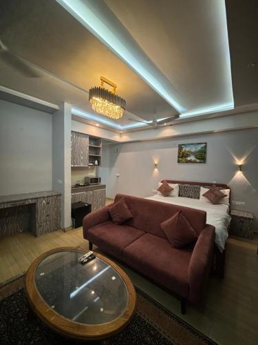 a living room with a couch and a bed at The Royal Suites Gomti Nagar Lucknow in Lucknow