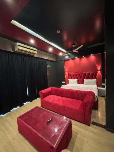 a red bedroom with a bed and a red couch at The Royal Suites Gomti Nagar Lucknow in Lucknow