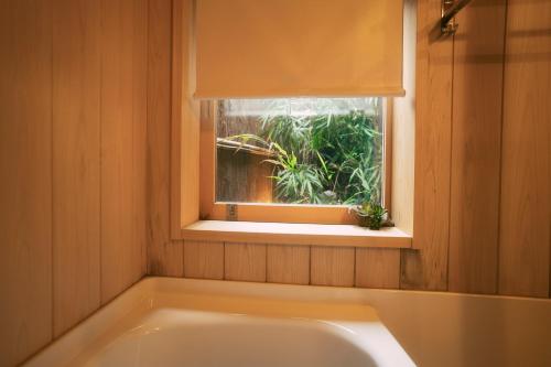 a bath tub in a bathroom with a window at 谷町君 星屋 清水家 京都清水寺二年坂 in Kyoto