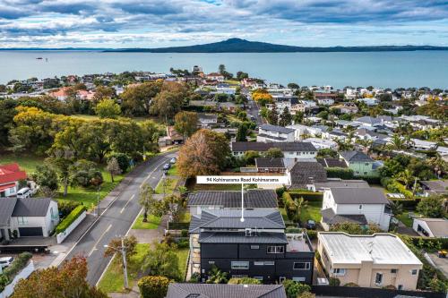 an aerial view of a town with houses and the water at The Bays Bed & Breakfast in Auckland