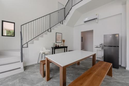 a kitchen and dining room with a table and a staircase at Gina Poolvilla89 Pattaya-Bangsaray to beach 900M in Bang Sare
