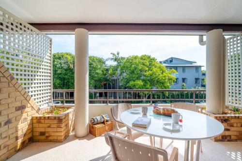 a patio with a table and chairs on a balcony at Byron Bayside Central Studio Apartments in Byron Bay