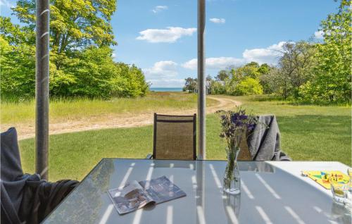 a glass table with a vase of flowers on it at Holiday Home Frederikshavn 52 Denmark in Sæby