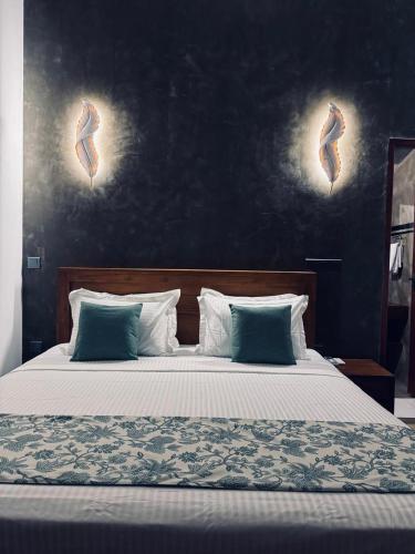 a bedroom with a large bed with blue pillows at Moonrise villa in Tangalle