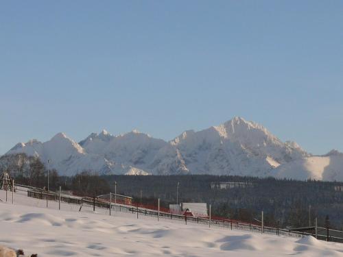 a snow covered mountain range with a fence in the foreground at Anna i Franciszek Żegleń Maćkulok in Male Ciche