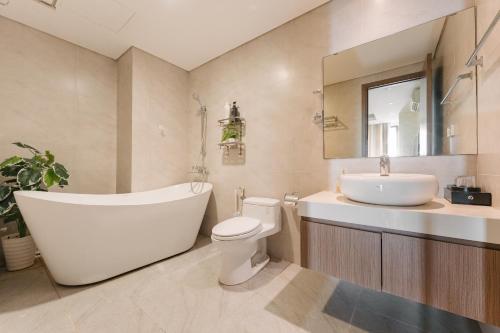 a bathroom with a tub and a toilet and a sink at H-Vista Suites - Hongkong Tower in Hanoi