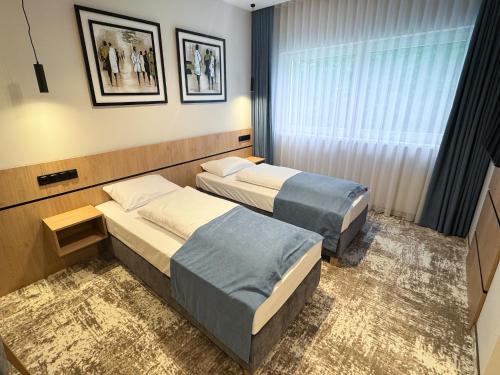 a hotel room with two beds and a window at Sarmata in Czyżówek