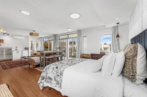 a bedroom with a white bed and a dining room at The Bays Bed & Breakfast in Auckland
