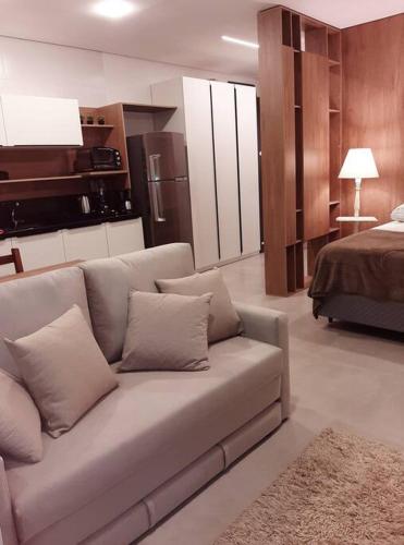 a living room with a couch and a bed at Studio Xavante 615A - com garagem, portaria 24h e uma vista linda! in Pelotas
