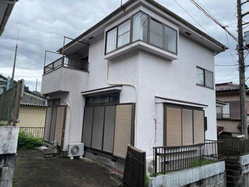 a white house with windows and a balcony at Karatake Valley in Hanno