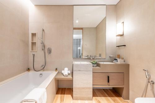 a bathroom with a tub and a sink at Address Beach Residences in Dubai