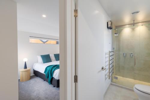 a bedroom with a bed and a shower and a toilet at Chatham Street - Christchurch Holiday Homes in Christchurch