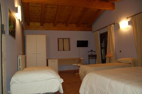 a bedroom with two beds and a desk in it at Country House Il Papavero in Bagnoli Irpino