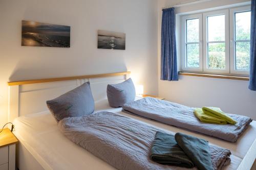 a bedroom with two beds and a window at Kaapdüne in Spiekeroog