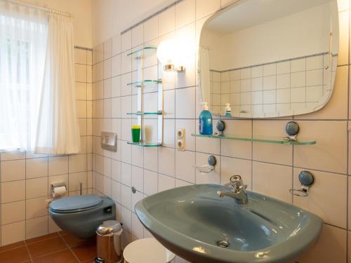 a bathroom with a sink and a blue toilet at Kaapdüne in Spiekeroog