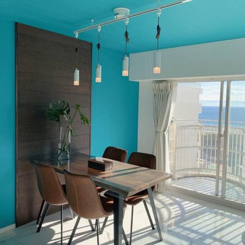 a dining table and chairs in a room with a window at Onjukuオシャンビューアジアントロピカル貸し切り御宿駅5分海岸2分 in Onjuku