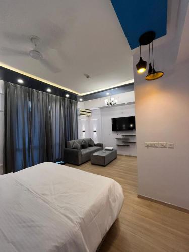 a bedroom with a large bed and a couch at The Royal Suites Gomti Nagar Lucknow in Lucknow