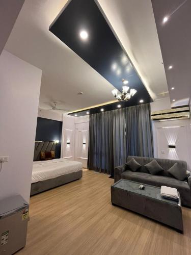 a living room with a couch and a bed at The Royal Suites Gomti Nagar Lucknow in Lucknow