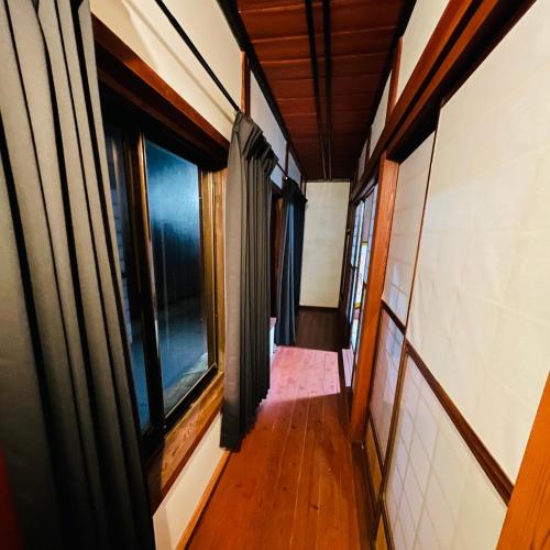an empty hallway in a house with windows at 夕日が海に沈む宿 まひるのつき in Shika