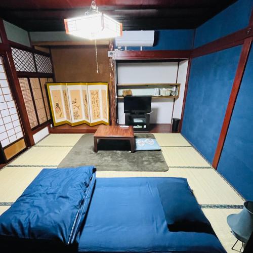 a room with a bed and a desk in it at 夕日が海に沈む宿 まひるのつき in Shika