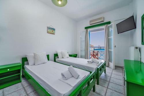 two beds in a room with a view of the ocean at Ancient Thera Apartments in Kamari