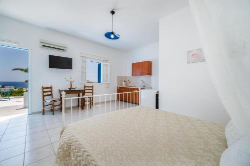 a bedroom with a bed and a kitchen with a table at Ancient Thera Apartments in Kamari