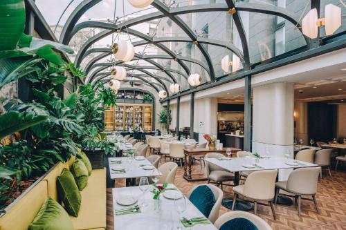 a restaurant with tables and chairs and plants at Shanghai Blackstone M Hotel in Shanghai
