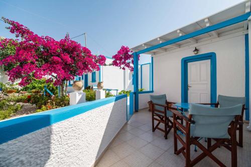 a balcony with a table and chairs and pink flowers at Ancient Thera Apartments in Kamari